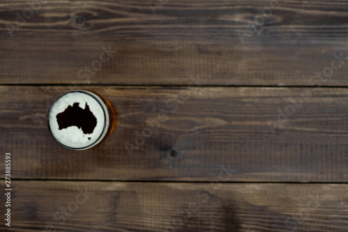 Mug of beer with silhouettes of Australia on foam. Top view. Space for text