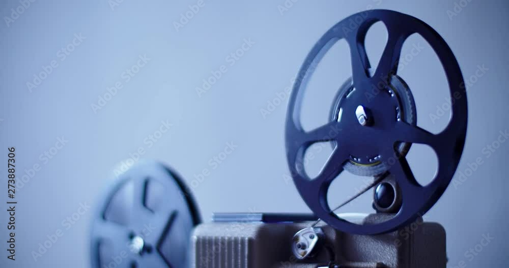 8 mm movie projector retro is playing. Vintage projector, blue color 4K DCI