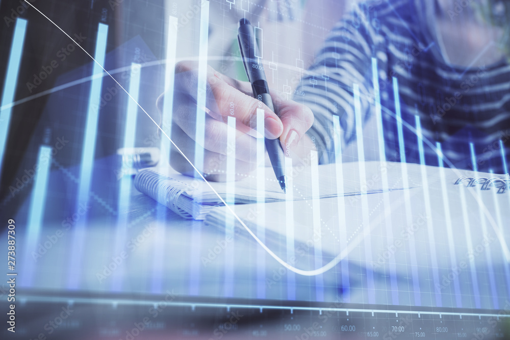 Financial forex graph drawn over hands taking notes background. Concept of research. Double exposure Financial forex graph drawn over hands taking notes background. Concept of research. Double exposure