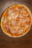 top view of whole pizza with prosciutto and pineapple pieces