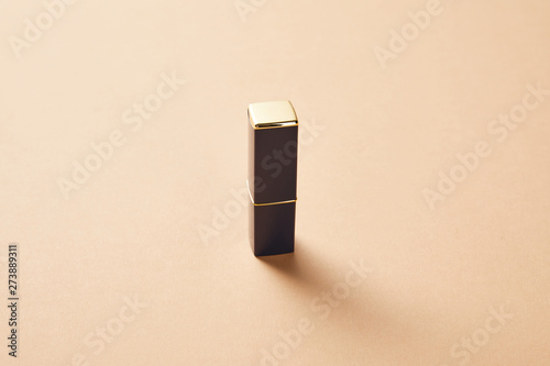 Fototapeta Naklejka Na Ścianę i Meble -  one tube of lipstick for makeup on beige