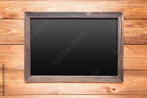 Blank chalkboard on brown wooden background