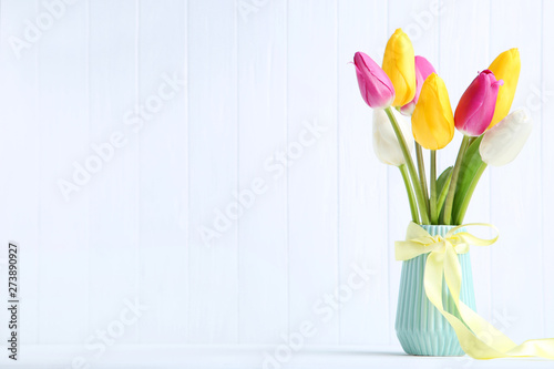 Bouquet of tulip flowers in vase on white background