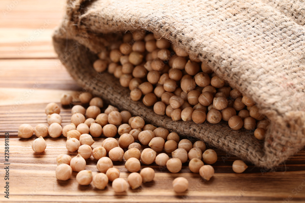 Chickpeas in sackcloth on brown wooden table Chickpeas in sackcloth on brown wooden table