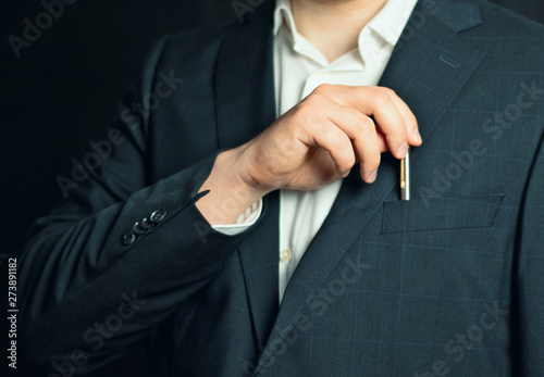 businessman in a suit taking or putting a pen from the breast pocket of his jacket