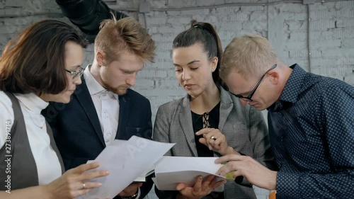 People standing together in office and checking agreement or doc
