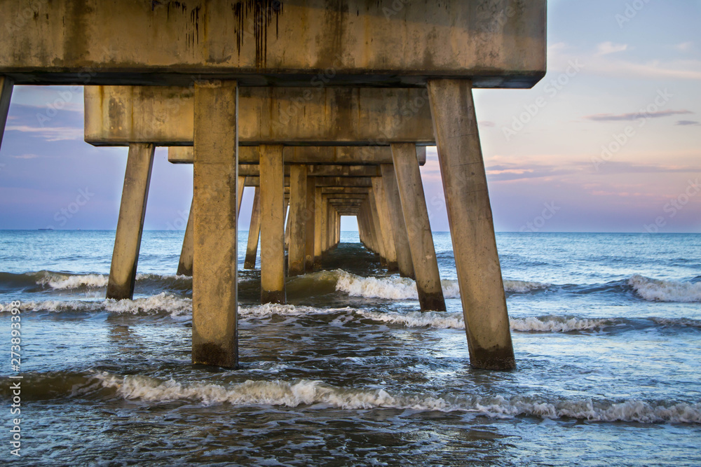 Crashing waves under fishing pier