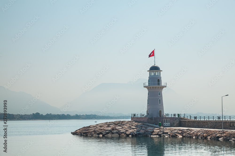 Sea lighthouse. Lighthouse in Alanya, Antalya district, Turkey. Popular tourist destination. Landscape with lighthouse in the harbor town of Alanya at dawn. Sea lighthouse. Lighthouse in Alanya, Antalya district, Turkey. Popular tourist destination. Landscape with lighthouse in the harbor town of Alanya at dawn.