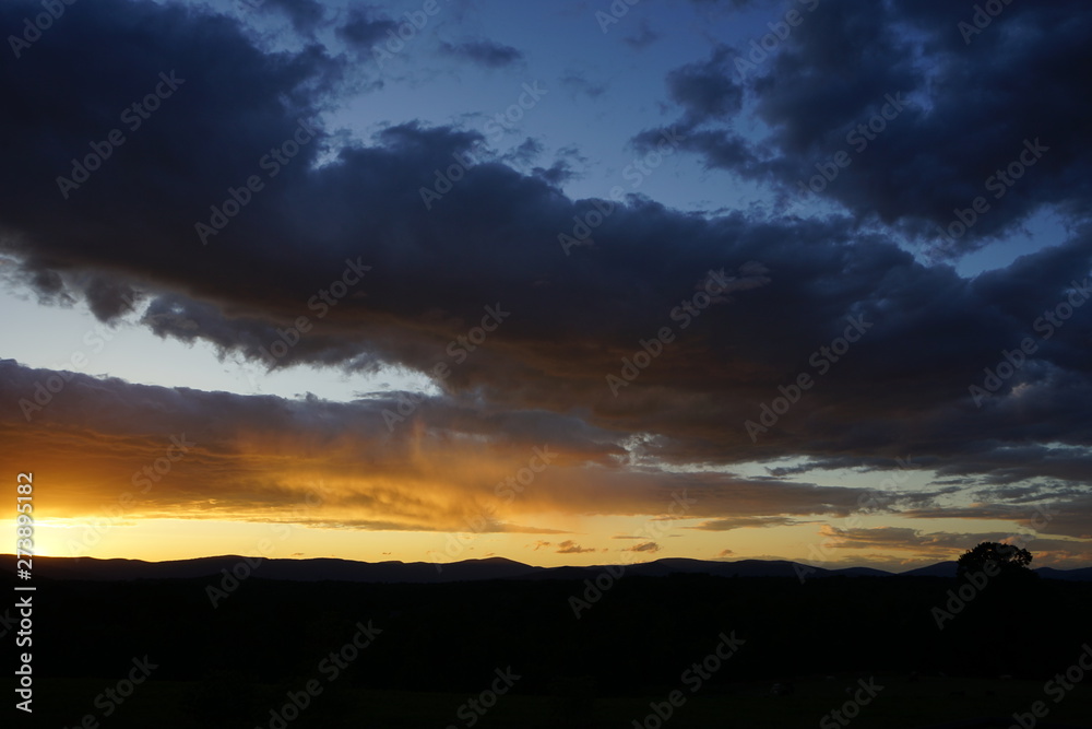 Fototapeta premium Brilliant Sunset with Clouds Over Mountains