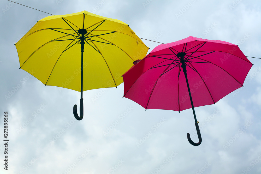 Yellow and red  color umbrellas on sky background.