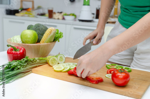 Diet. young pretty woman in green shirt cutting cooking and knife preparing fresh vegetables salad for good healthy in kitchen at home, healthy lifestyle, cooking, healthy food and dieting concept