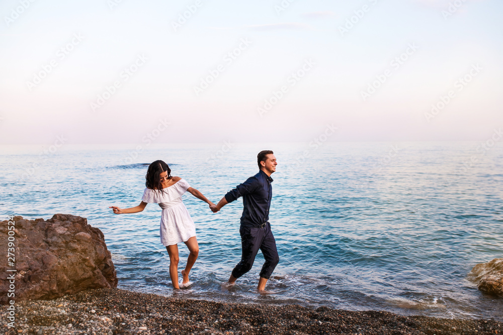 Romantic couple in the sea water have fun together.