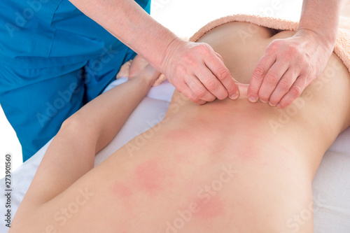 Osteopath massages patient s back. Skin lift