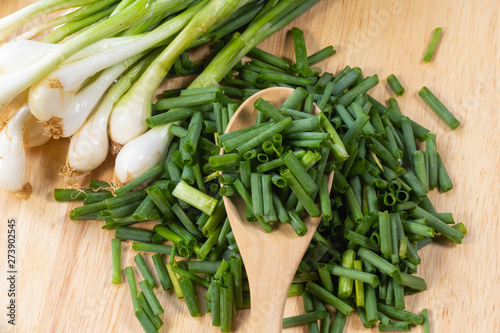 chopped of fresh scallion or spring onions on wooden board