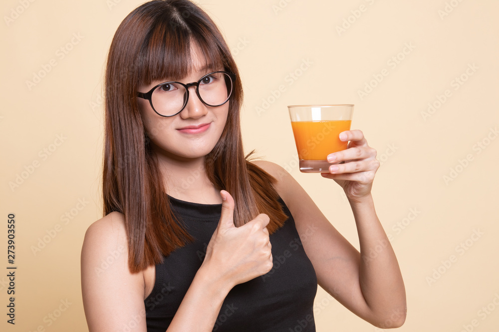 Young Asian woman thumbs up drink orange juice. Young Asian woman thumbs up drink orange juice.