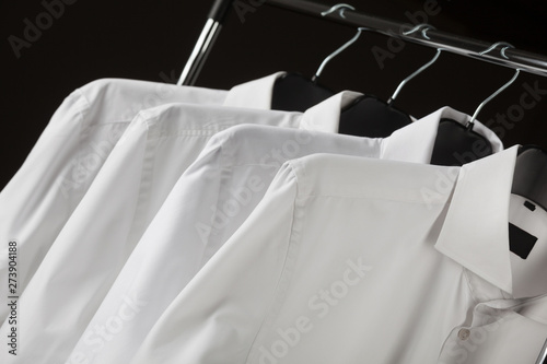 Man's classical shirts hanging in a row