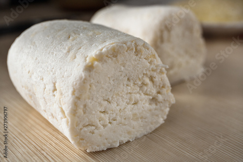 Two pieces of cottage cheese dough are on the table. Close-up of yeast-free dough for healthy eating.