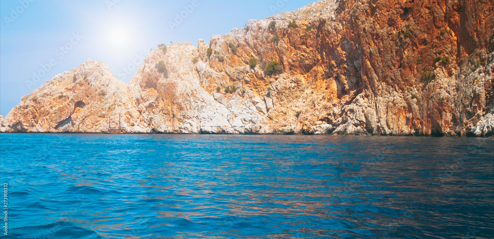 Panorama view of Mediterranean Sea and stone rocks in the rays of the sun. Scenic image of most popular tourist attraction.