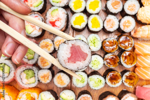 top view of chopsticks with roll over many sushi