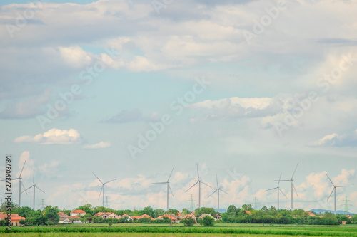 Wind warm behind small village with cloudy sky in background
