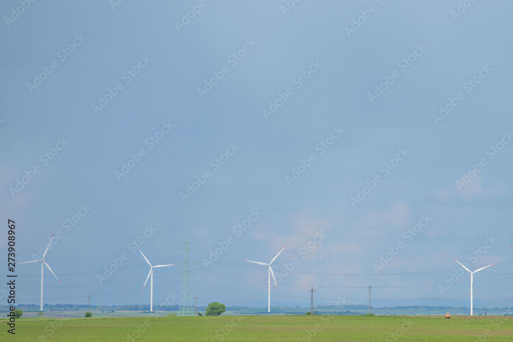 Wind warm on agricultural ground with cloudy sky in background Wind warm on agricultural ground with cloudy sky in background