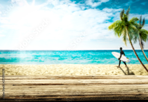 Fototapeta Naklejka Na Ścianę i Meble -  Desk of free space and blurred background of beach with surfer. Summer time and sunny day. 