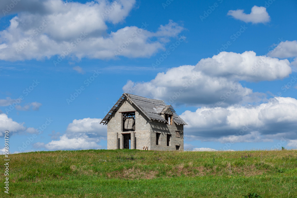 unfinished house on the green field against blue sky unfinished house on the green field against blue sky