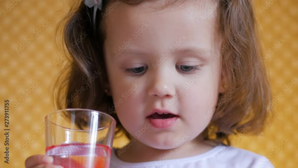 Cute little child girl drinking a glass water at home Cute little child girl drinking a glass water at home