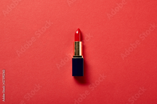 top view of single tube of red lipstick on red