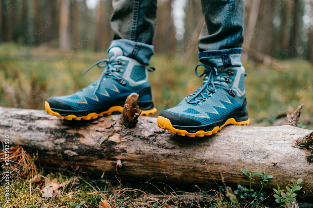 Male legs wearing sportive hiking shoes outdoor. Mens legs in trekking boots for outdoor activity Male legs wearing sportive hiking shoes outdoor. Mens legs in trekking boots for outdoor activity