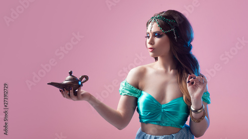 Fotografie Oriental fairy tale, a young Princess woman with a magic lamp in her hands