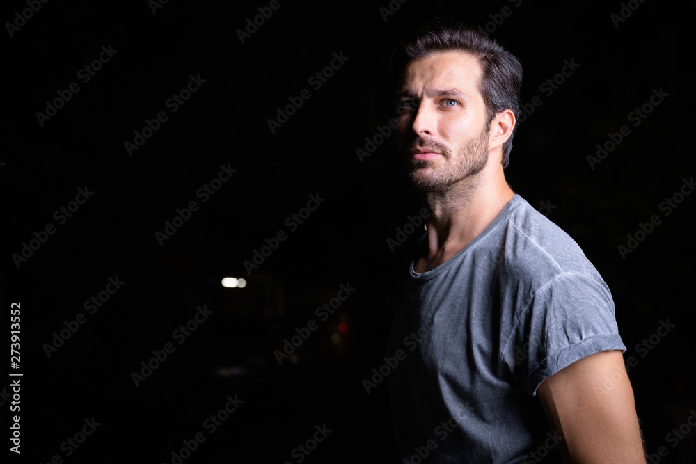 Portrait of handsome bearded man thinking outdoors at night