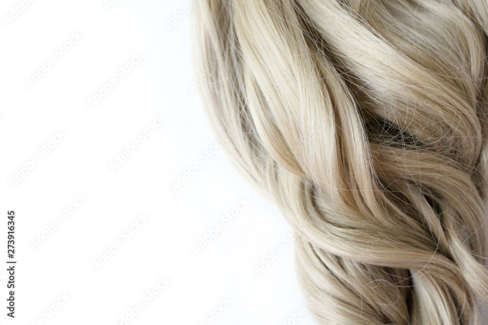 Beautiful wavy hair. Light brown hair. Hair is gathered in a bun on a white background. With free space for text. For a poster or business card. Beautiful wavy hair. Light brown hair. Hair is gathered in a bun on a white background. With free space for text. For a poster or business card.
