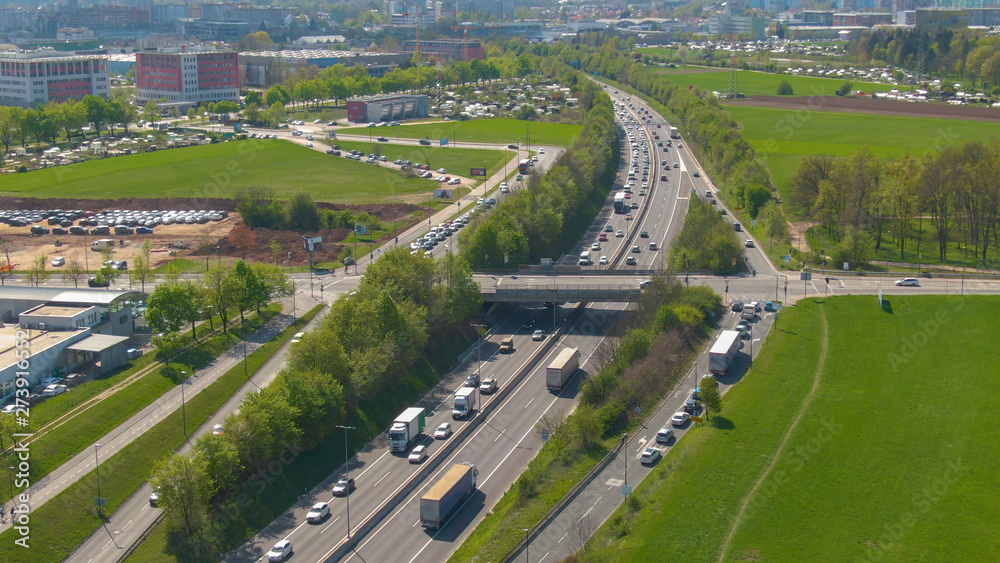 DRONE: Countless vehicles form a traffic jam on the highway near a modern city.