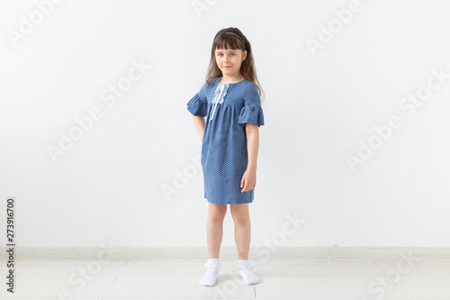 Adorable child girl in blue dress over the white background © satura_