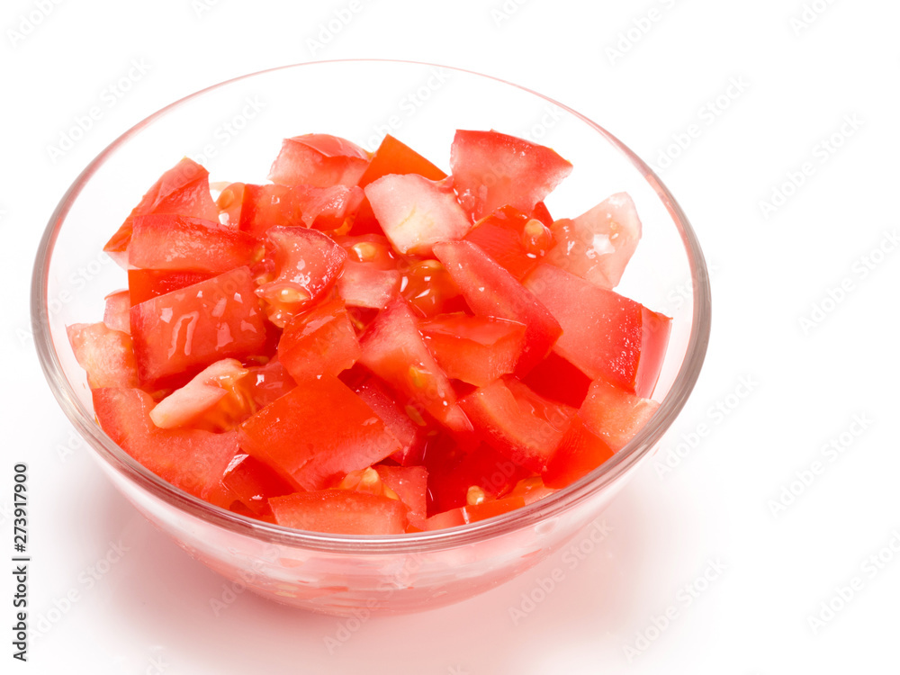 Sliced tomato in a transparent bowl on white background Sliced tomato in a transparent bowl on white background
