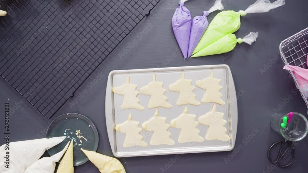 Flat lay. Decorating unicorn sugar cookies with multi-color royal icing.