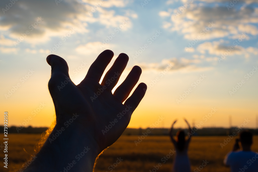 Silhouette of freedom male hand in field enjoy a sunset