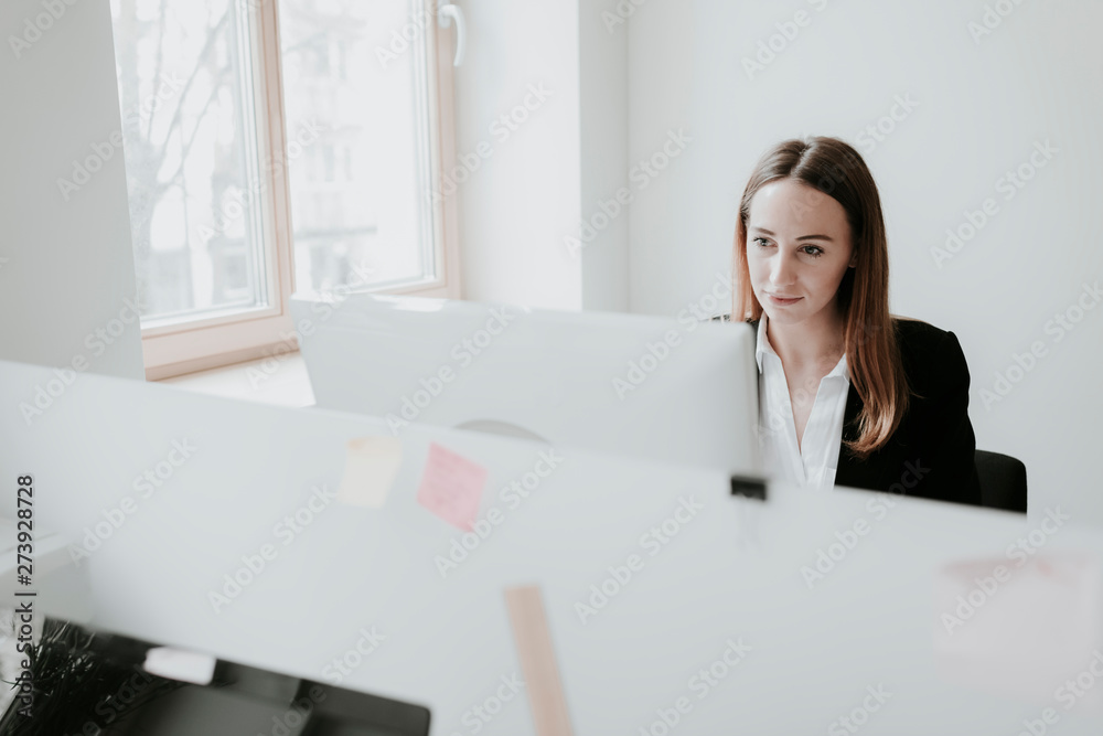 Young woman using computer at desk in office Young woman using computer at desk in office