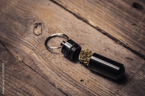 storing cannabis cones in a keychain container in the form of a bullet close-up. carrying and storing legalized soft drug in pocket crisper