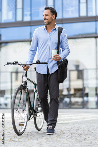Businessman with bicycle on the go in the city