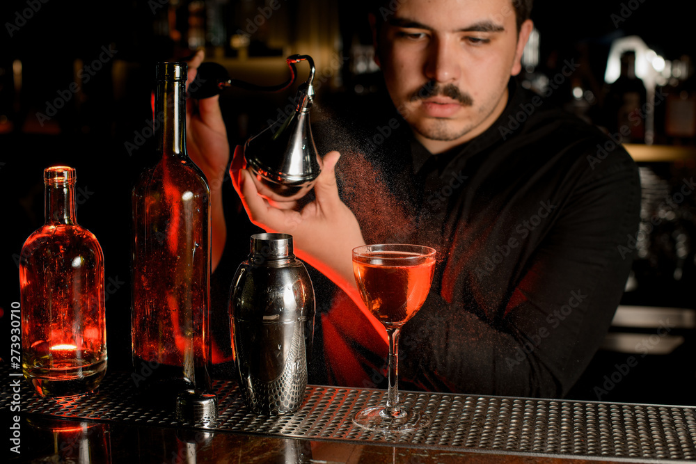 Bartender using sprayer to make a cocktail
