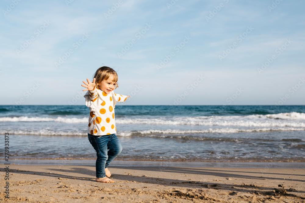 Happy little girl running barefoot on the beach Happy little girl running barefoot on the beach