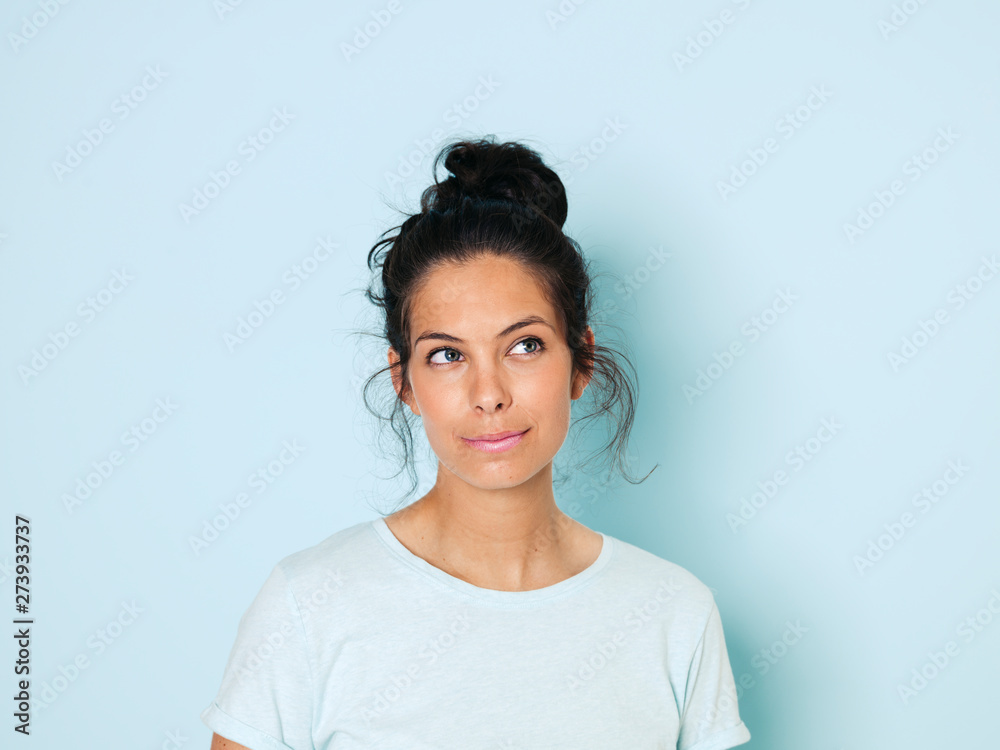 Portrait of young woman with black hair, light blue background Portrait of young woman with black hair, light blue background