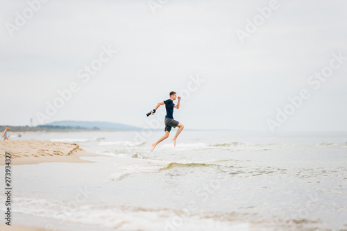 man with a camera in his hand jumped over sea