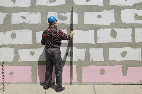 House renovation, polystyrene wall insulation, level tool © sima