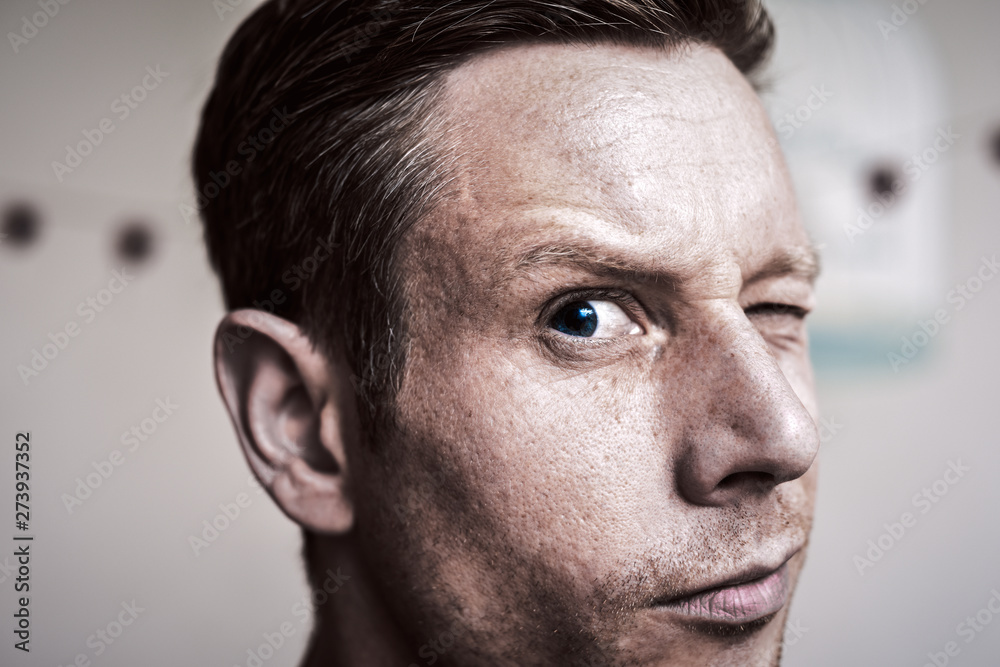 Obraz premium Serious but inquisitive looking man with raised eyebrow looking directly at camera
