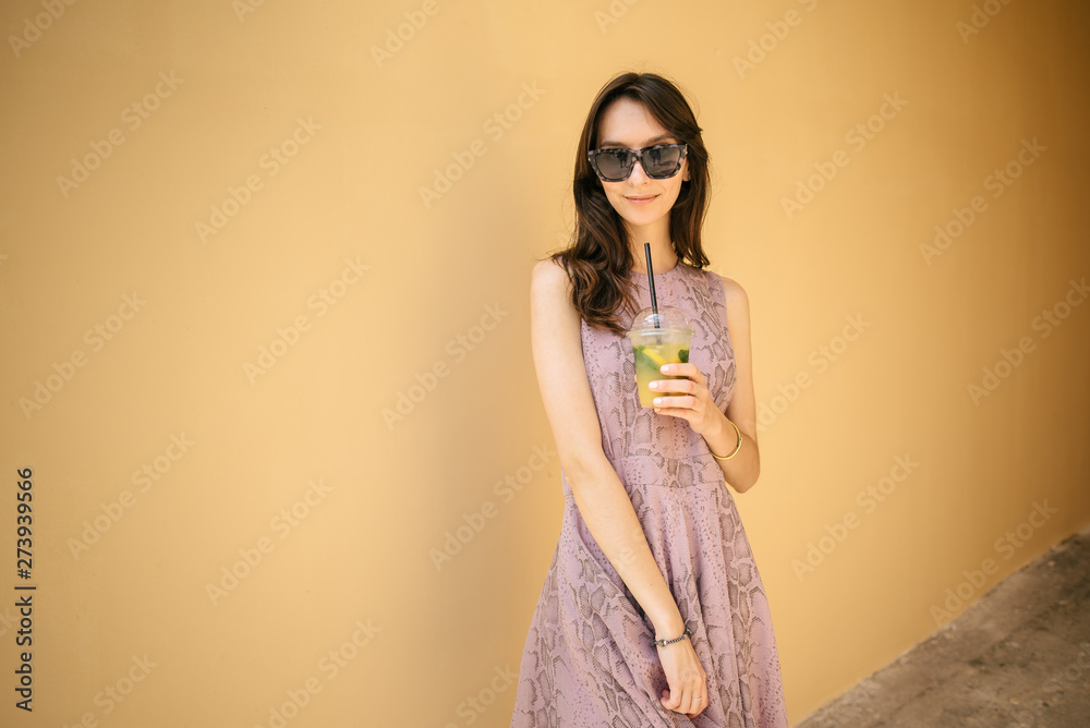 beautiful young girl in dress with lemonade outdoors, woman resting, walking on the street beautiful young girl in dress with lemonade outdoors, woman resting, walking on the street