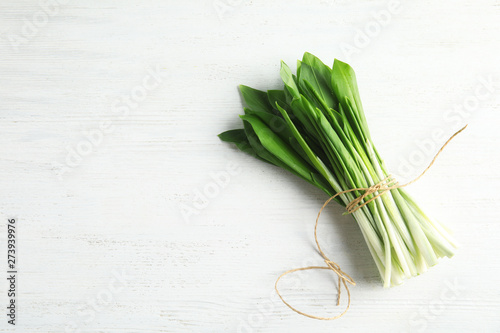 Bunch of wild garlic or ramson on white wooden table  top view with space for text