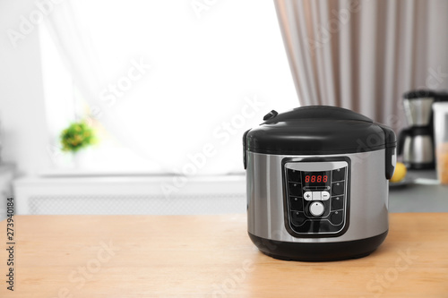 New modern multi cooker on table indoors. Space for text